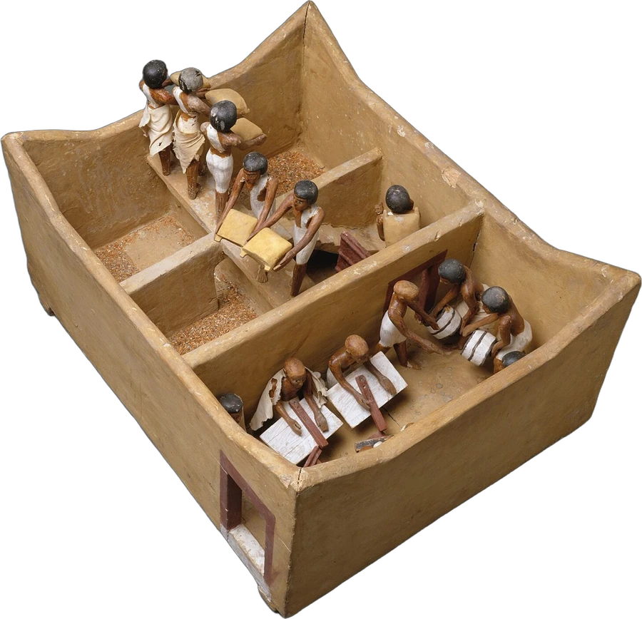An Egyptian wooden model of a granary with scribes counting the grain as it is carried in
